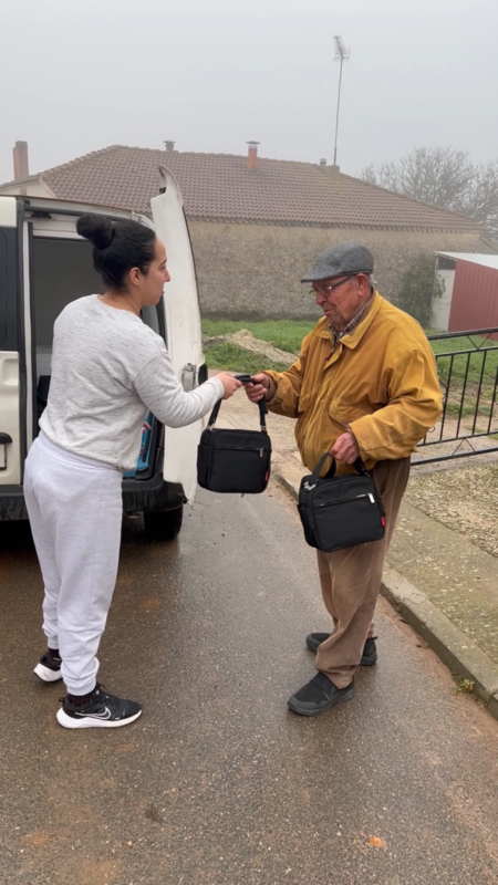Lorena, una de las trabajadoras de CODINSE, entregando la comida a Domingo en Navares de Ayuso.