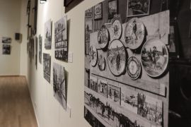 Colección de cerámica decorativa entre las fotografías de la exposición de Daniel Zuloaga