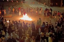Ayllón concentra a un público numeroso en torno a una hoguera que es saltada por varias personas.