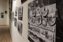 Colección de cerámica decorativa entre las fotografías de la exposición de Daniel Zuloaga